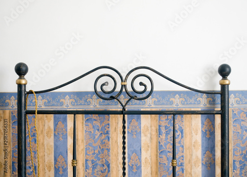 Tableau sur toile wrought iron old-fashioned  bedstead against decorated wall