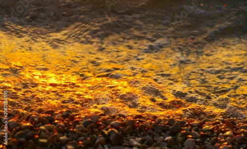 Fotografie Golden sea in sunset on the pebbles beach sparkle and shine, summertime beach ba