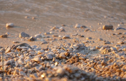 Obraz na plátně Golden sea in sunset on the pebbles beach sparkle and shine, summertime beach ba