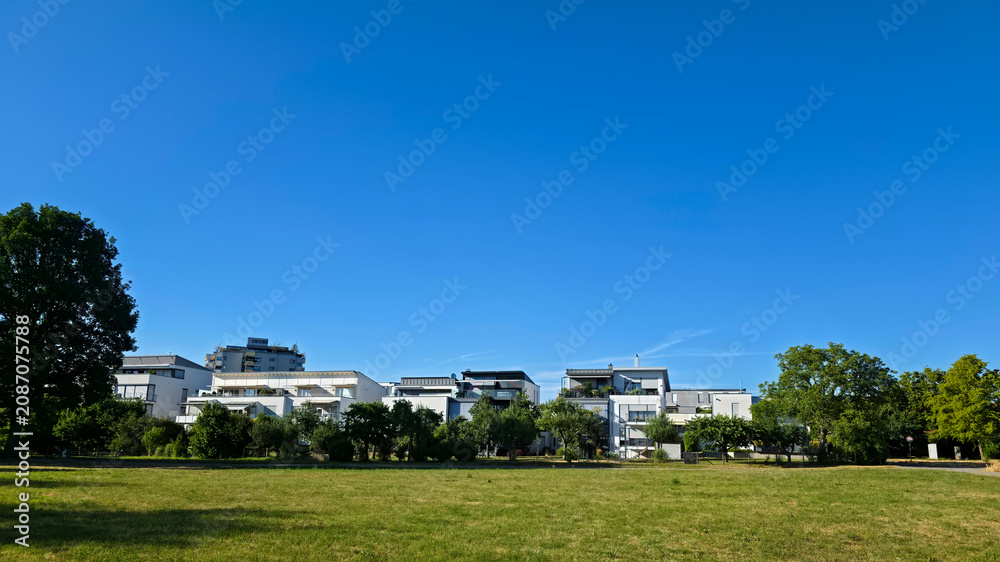 Fototapeta premium germany, beautiful panoramic green meadows surrounding ostfildern ruit residential skyline beneath glowing summer sunshine and endless blue sky