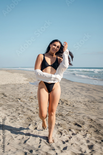 Woman running on sandy beach feeling carefree during a warm sunny day