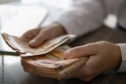 Canvastavla Hands of a person handling a large stack of 50 euro banknotes, carefully countin