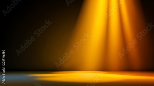 Stage with golden spotlight shining onto a blank black background for performance or presentation setting