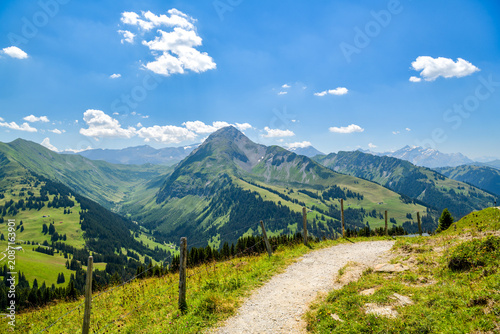 Mountain path along a fence toward a rocky peak