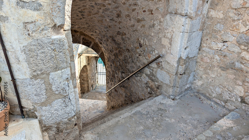Canvastavla Ancient stone stairs leading down through historic arched passageways inside a m