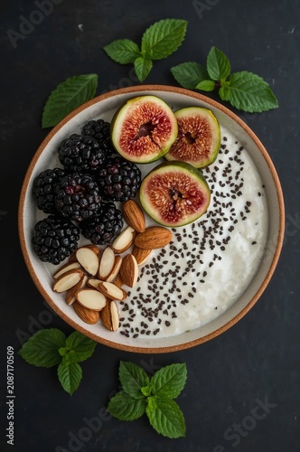 Healthy Bowl With Berries, Figs, Nuts, and Mint on a Dark Table