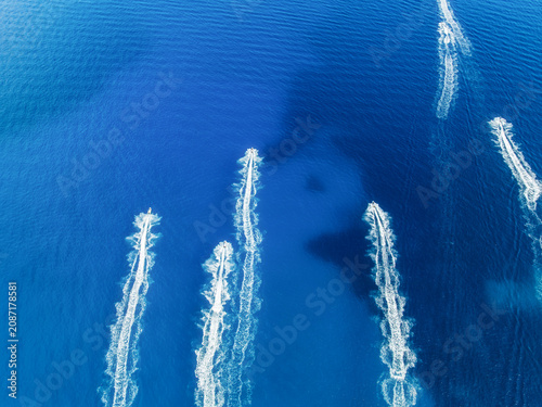 Aerial drone view of a team riding water scooters in the sea. Friends having ...
