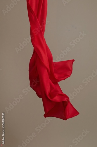Silk Fabric in Red Color Hanging Down Against a Simple Background