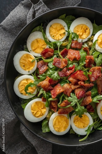 Delicious Salad With Boiled Eggs and Crispy Bacon on Fresh Greens