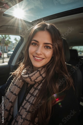 Young Woman Smiles While Sitting in Car on City Street During Sunny Day