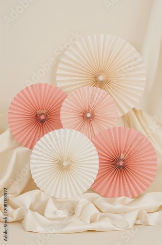 Decorative Paper Fans Arranged on a Light Surface in a Simple and Minimal Set...