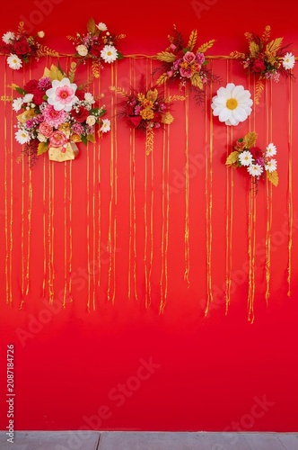 Colorful Flower Decorations Hanging on a Red Wall in a Festive Setting for an...