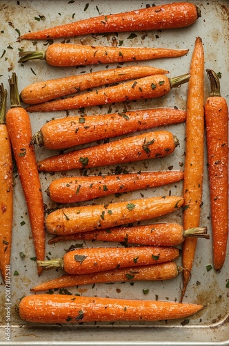 Fresh Carrots Arranged on a Baking Tray With Herbs on a Kitchen Countertop in...