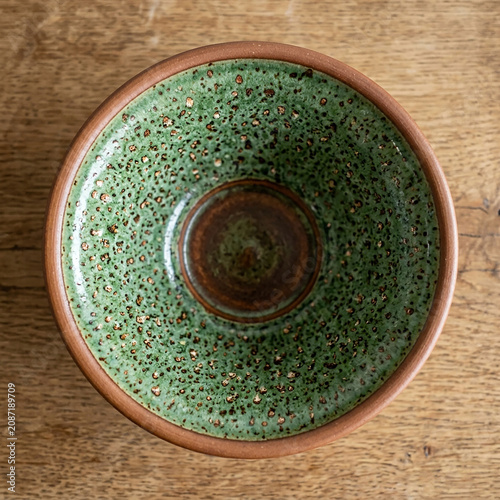 Top View Ceramic Bowl with Speckled Glaze on Wooden Surface Minimalist Style