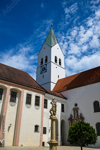 White church tower with clock and blue sky