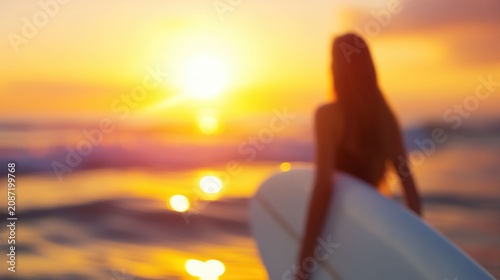 A woman is walking on the beach holding a surfboard at sunset.