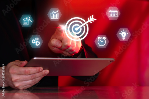 Business professional tracking objectives, milestones and project performance using digital target dashboard and workflow management interface.