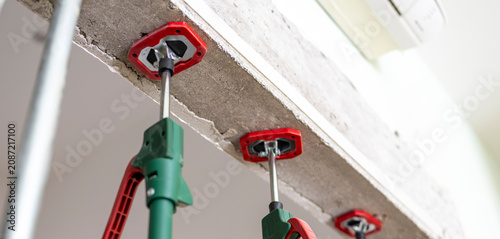Fotografie Heavy-duty steel acrow props securing a concrete wall throughout renovation, preventing movement and maintaining structural integrity during the curing process