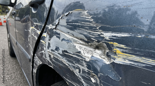 A car shows deep scratches and dents on its side