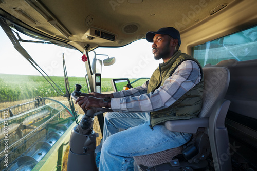 Obraz na płótnie Farmer operating a combine harvester during harvest season in a modern agricultural operation