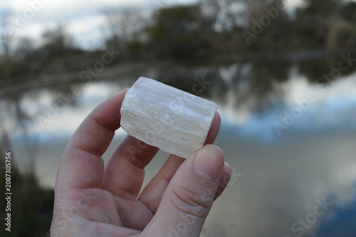 hand with selenite mineral on the lagoon 