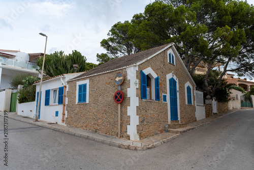 Charming stone house with blue shutters on quiet residential street