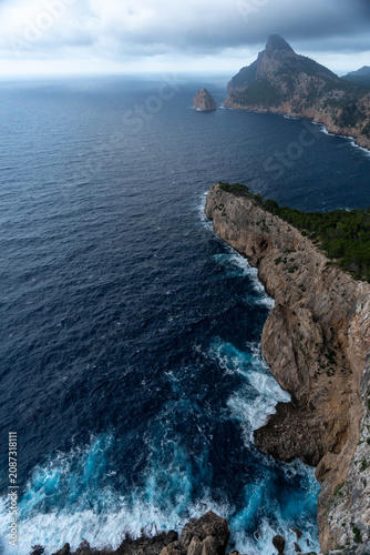 Dramatic coastal cliffs and deep blue sea under storm clouds