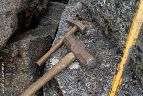 Geological hammers on exposed rock outcrop during fieldwork