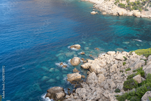 Aerial view of turquoise coastal waters and rocky shoreline