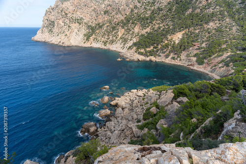 Breathtaking view of a secluded rocky bay with crystal-clear turquoise water surrounded by cliffs
