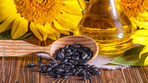 Φωτογραφία Rural still-life - the sunflower oil in glass cruet with flowers of sunflower (H
