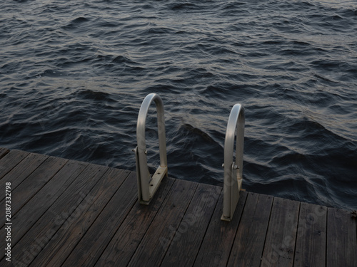 Foto Metal Dock Ladder Above Dark Choppy Lake Water