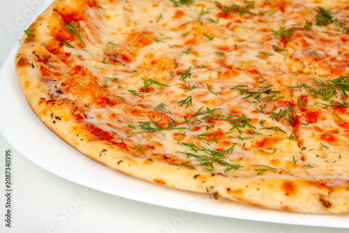 A closeups shot of a baked margherita pizza with melted cheese tomato sauce and fresh chopped herbs. Italian fast food, macro cheesy pastry, savory dinner dish meal. Dining.