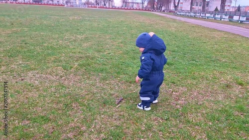 Toddler in jumpsuit taking first steps on grass