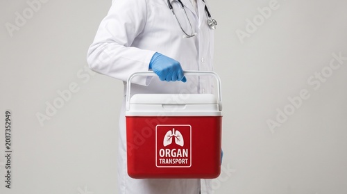 Doctor holding an organ transport cooler with lungs symbol