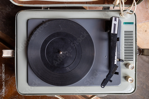 Vintage record player with black vinyl record on top.