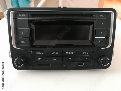 Front view of a Volkswagen car radio with media menu and FM AM control buttons.