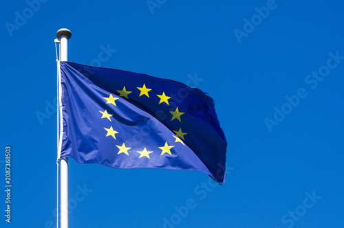 European Union flag waving against a clear blue sky in Campione d'Italia