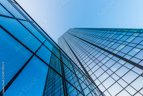 Modern blue glass office tower with sharp vertical perspective.