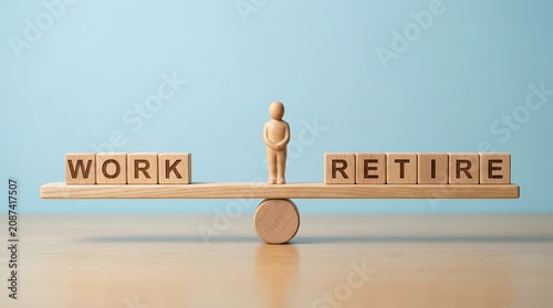 Wooden figure on a balance plank between work and retirement spelling blocks for life stability