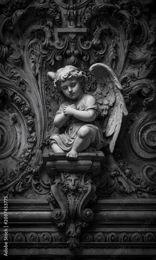 Obraz premium Angel sculpture sits on a stone wall.