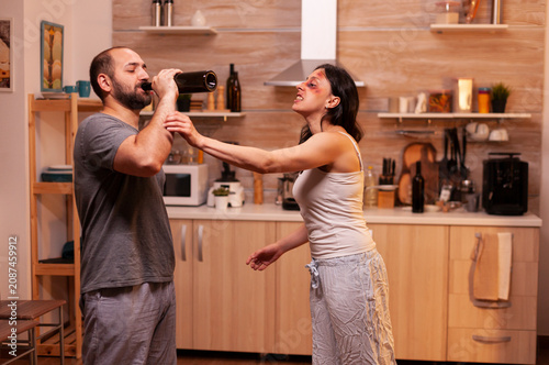 Obraz na plátně Furious traumatized wife faces a violent husband at home at night after abuse, showing fear, pressure and relationship danger in a domestic crisis