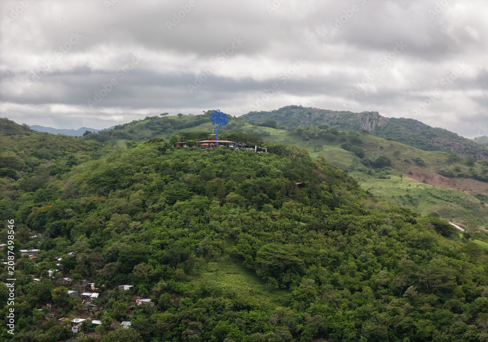 Naklejka premium View of a hilltop site with a blue structure and greenery below
