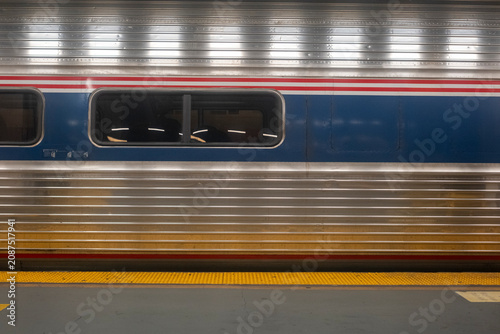 Train side view showing metallic texture and window at station platform