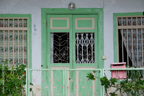 Traditional pastel green house facade with vintage doors and windows in Penang Malaysia