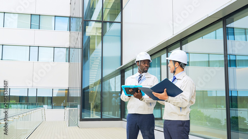 Photos A group of multinational engineers inspecting a building.