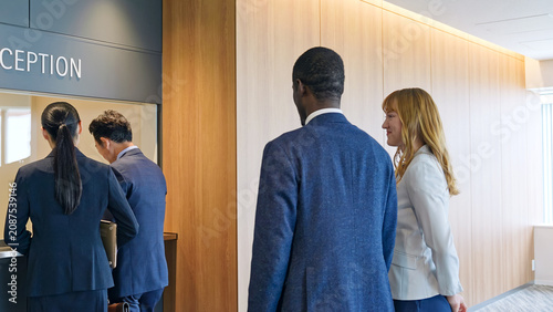 Schilderij op canvas A group of multinational businesspeople completing procedures at the reception desk