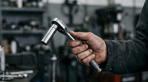 Person holding a wrench in a workshop setting