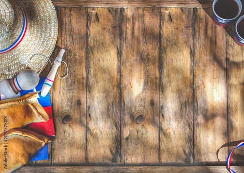 Chilean independence day concept. fiestas patrias. Tipical baked empanadas, fat and play emboque. Decoration for 18 september party day, wooden background