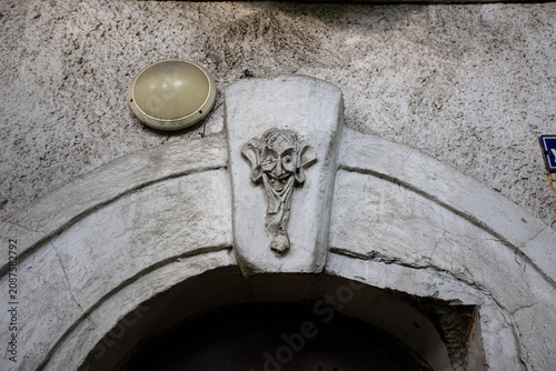 Kaliningrad, Russia - June 5, 2026: A stucco molding in the form of a scary human face with large ears and teeth above the entrance to a residential building on Alexander Nevsky Street in Kaliningrad